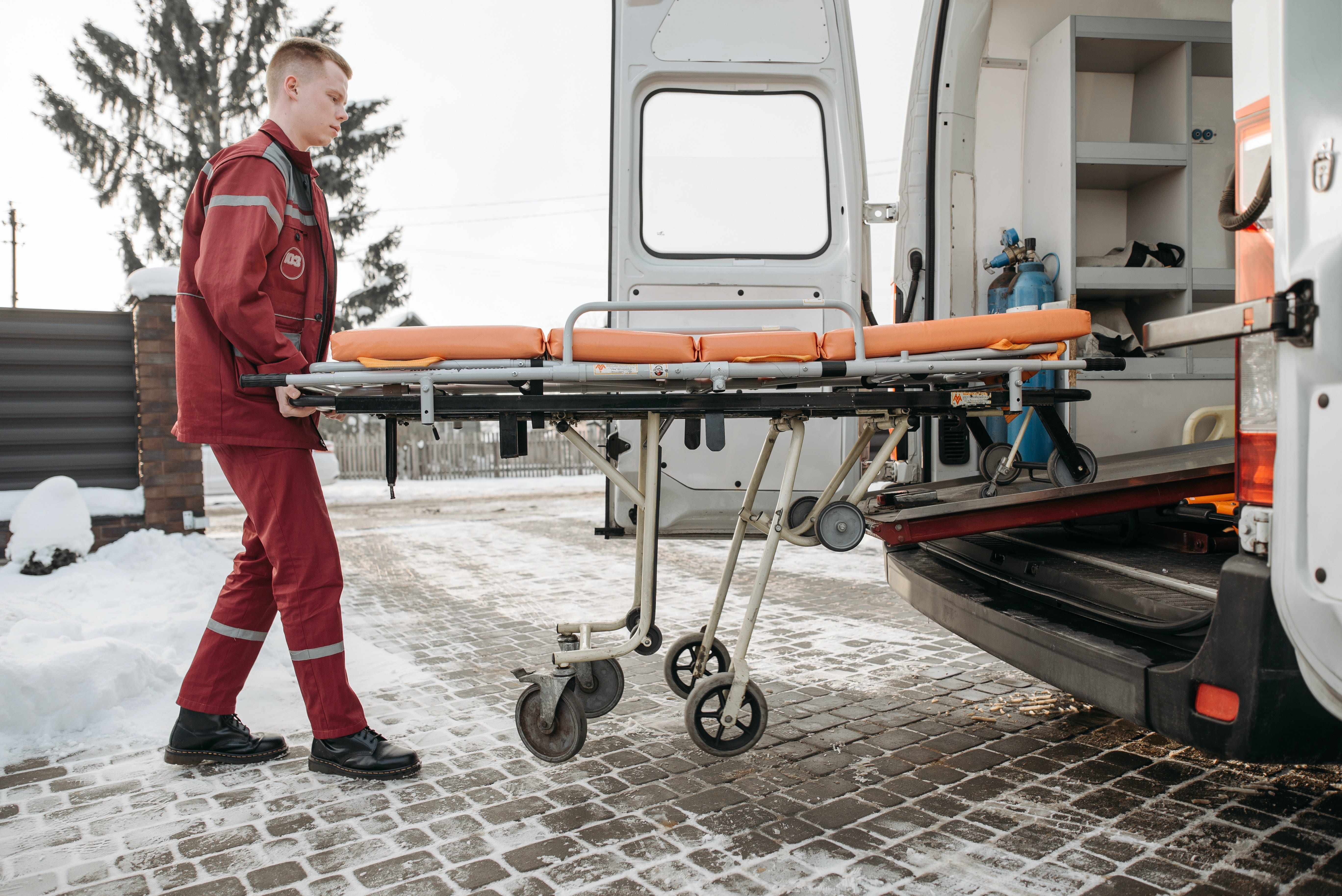 Paramedic moving an empty stretcher
