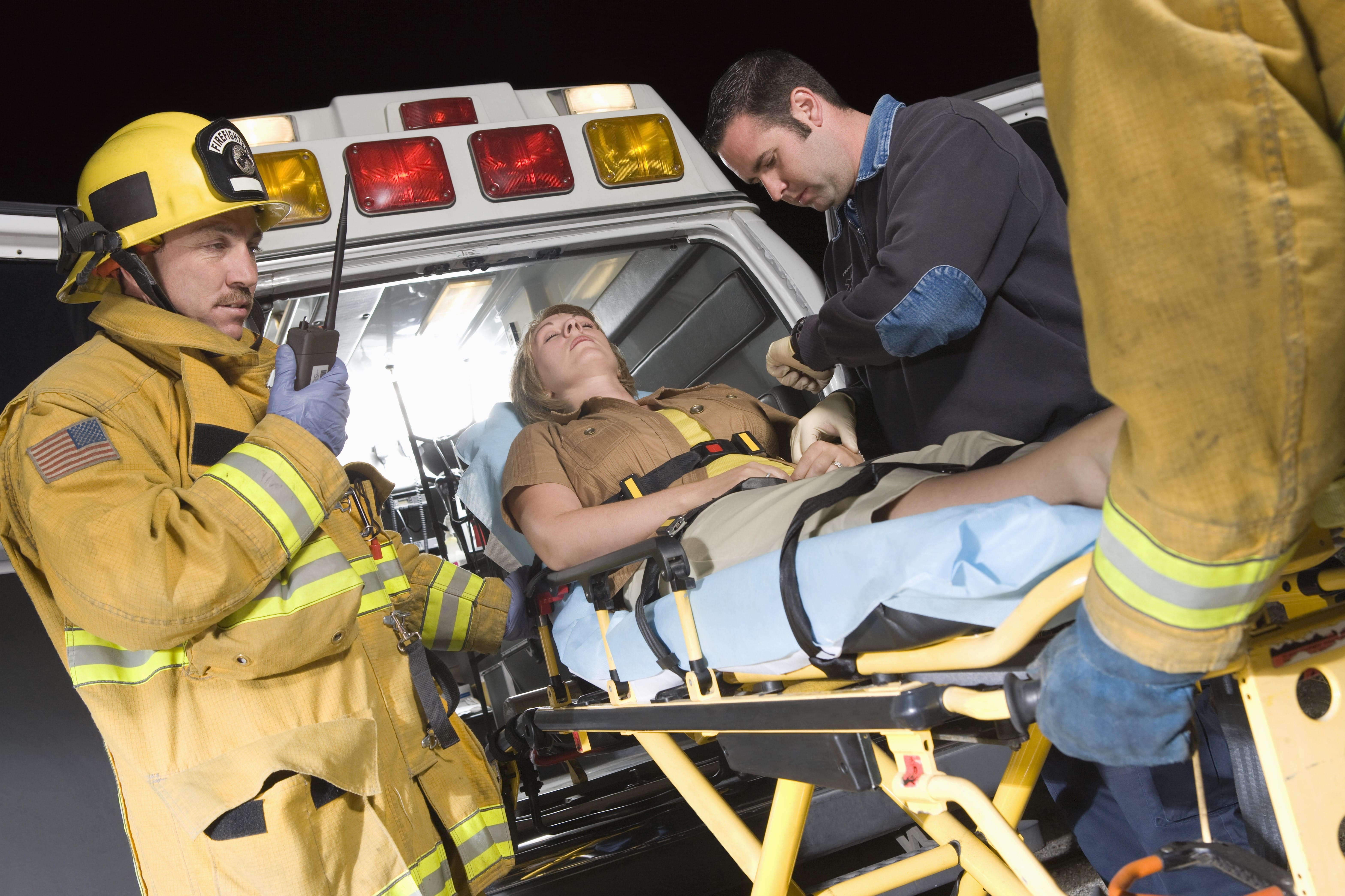 EMS team loading a woman into an ambulance