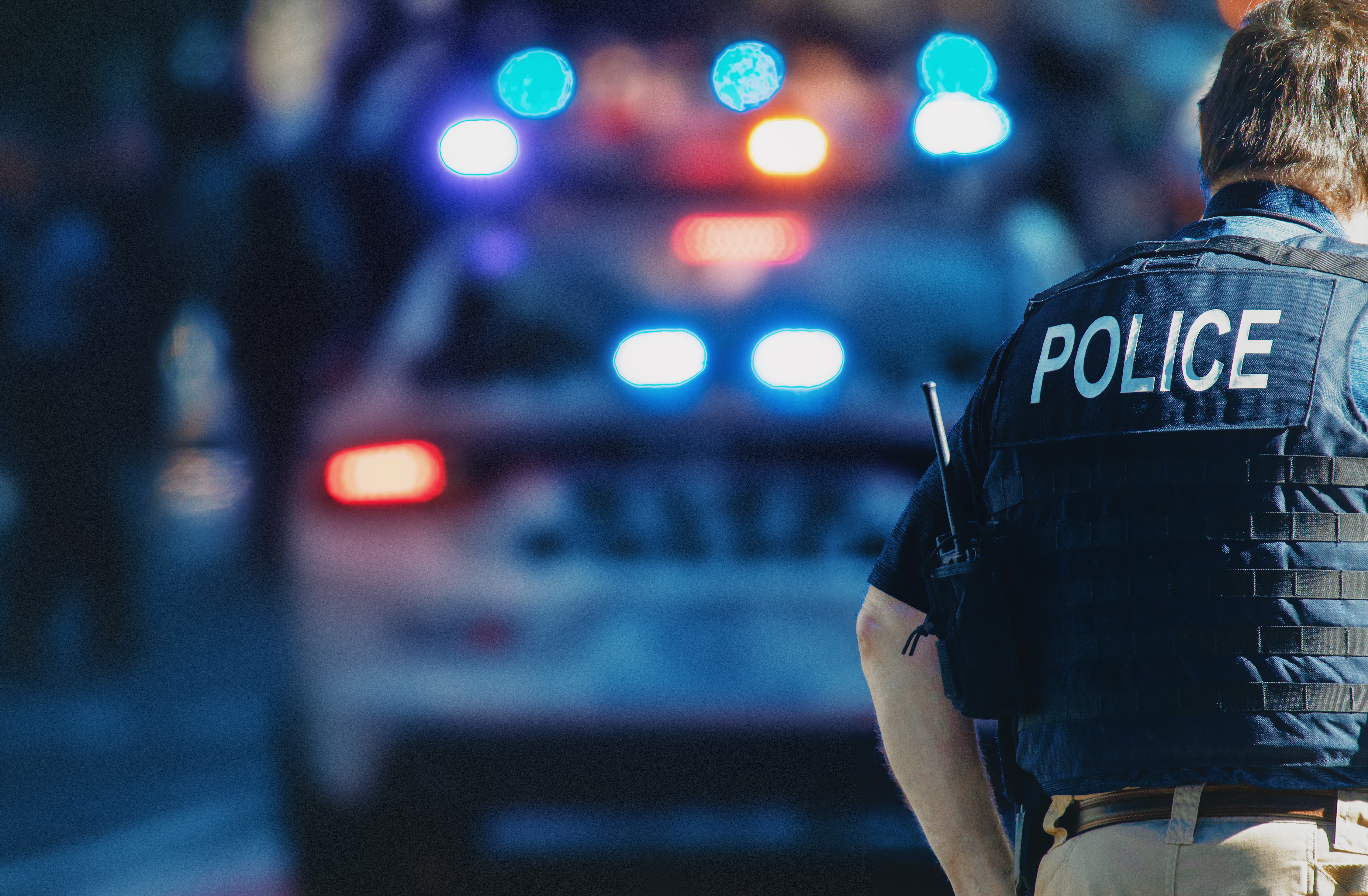 Police officer standing in front of a patrol car