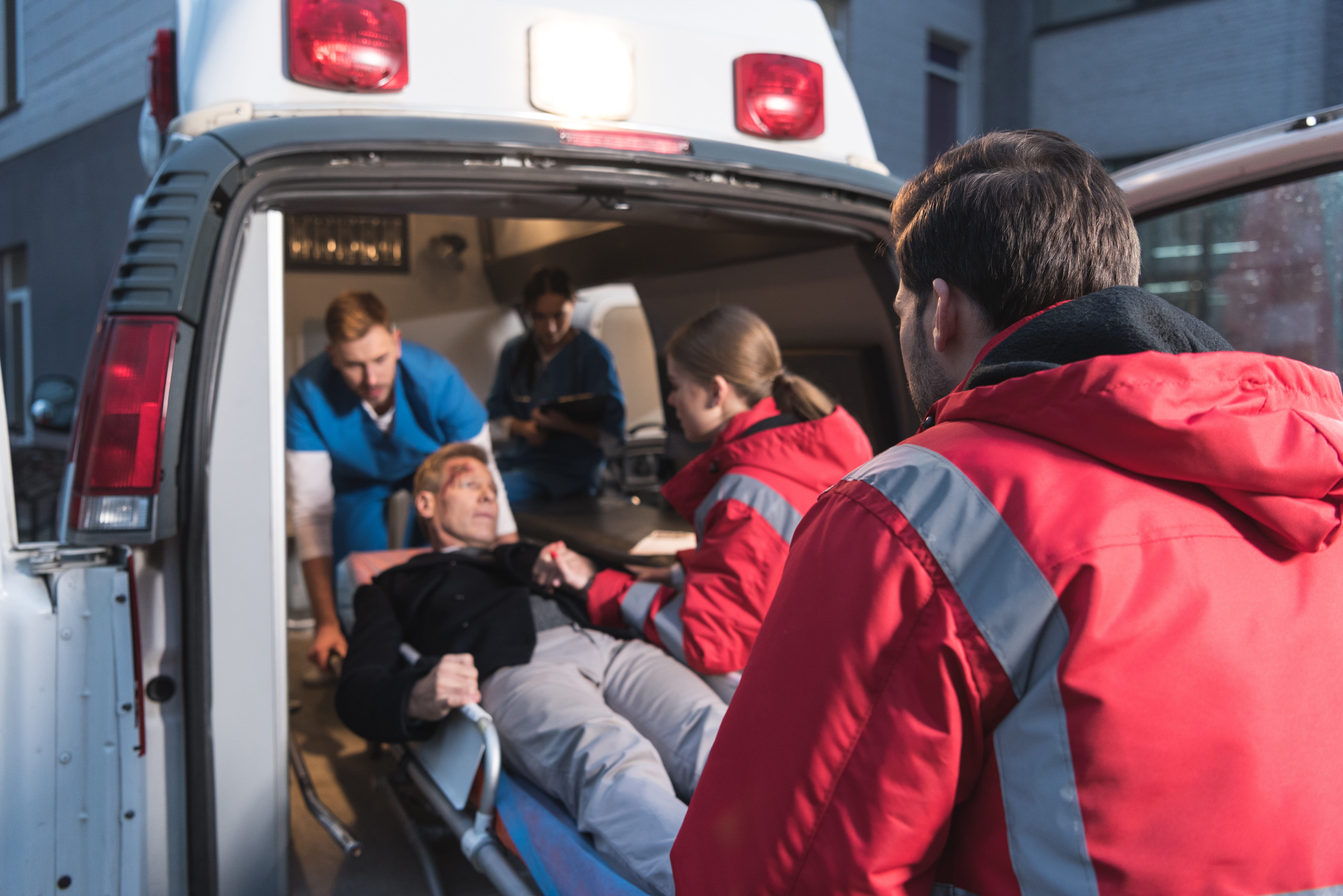 Team of EMS workers moving a wounded man