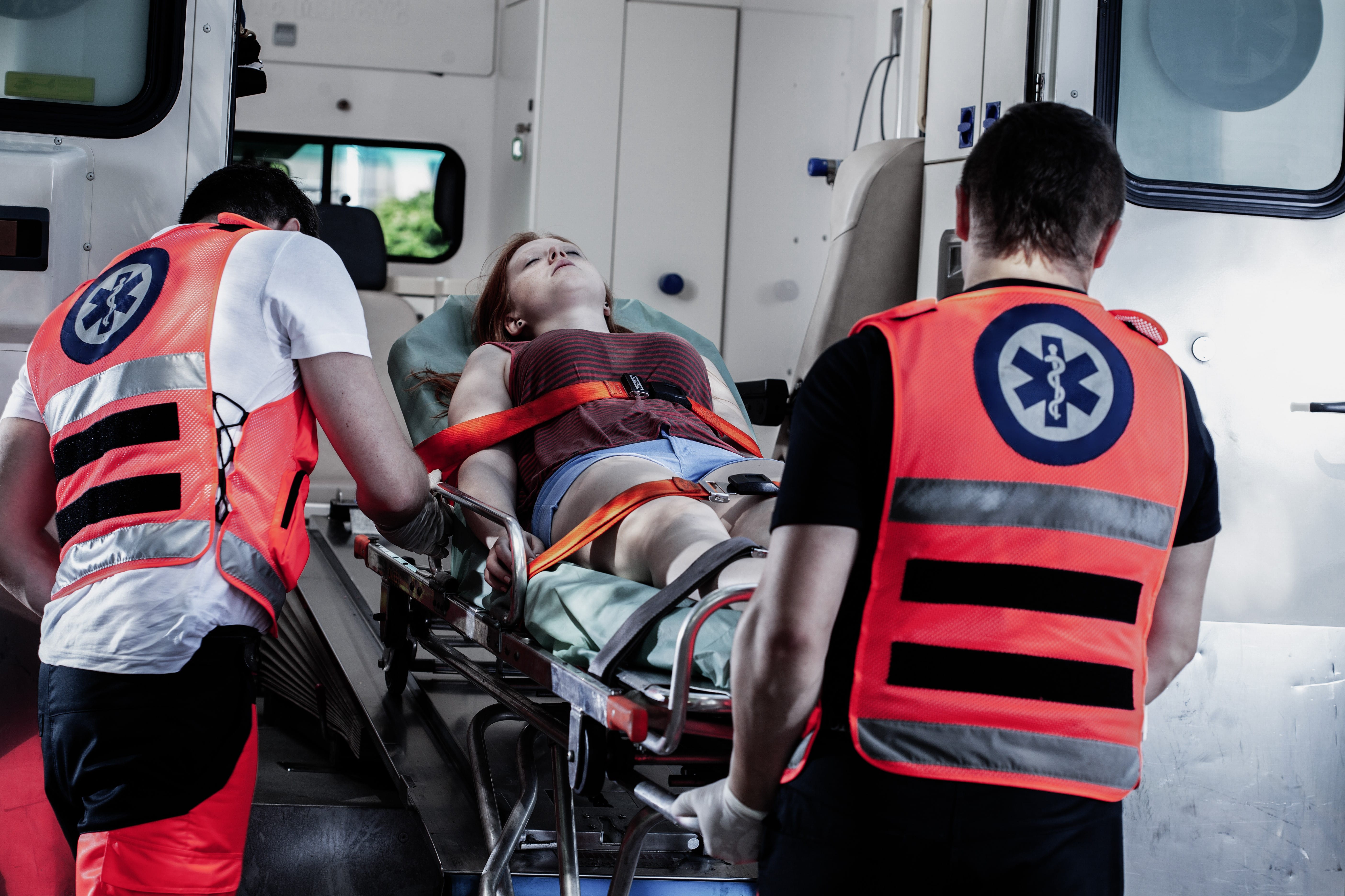 Young female victim on a stretcher with EMS workers