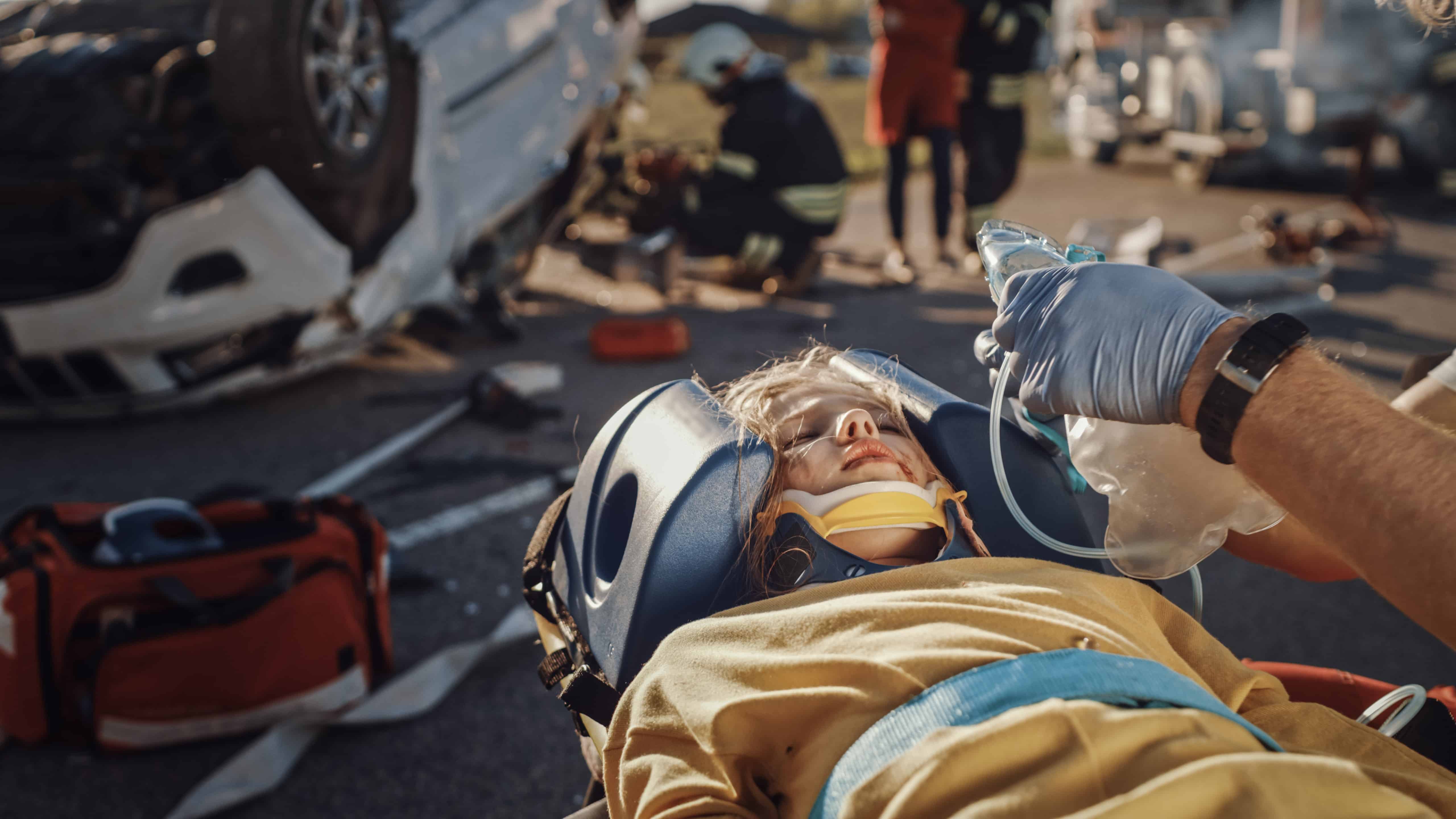 EMS professionals tending to a child in a car crash