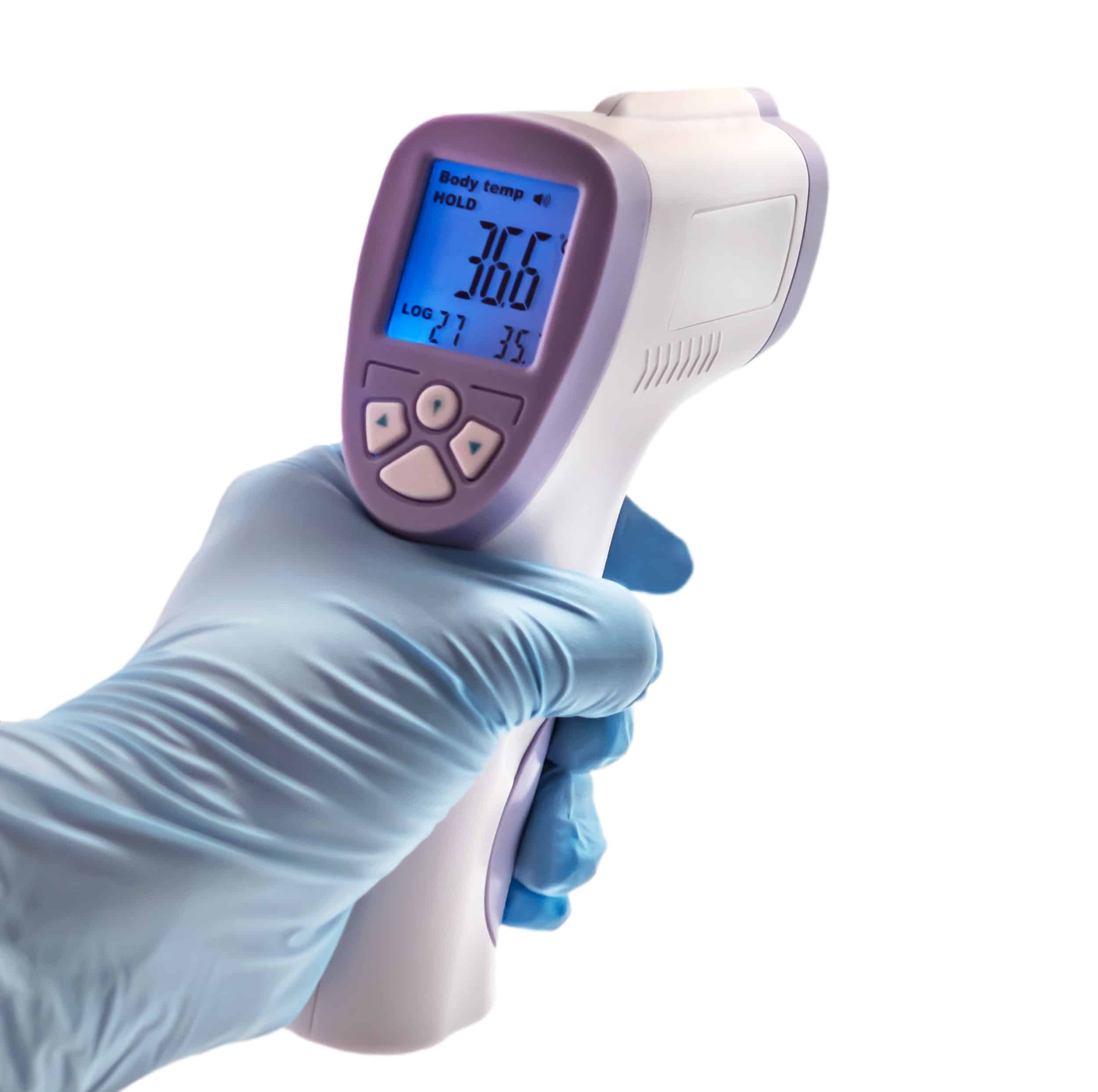 Gloved hand holding a thermometer device