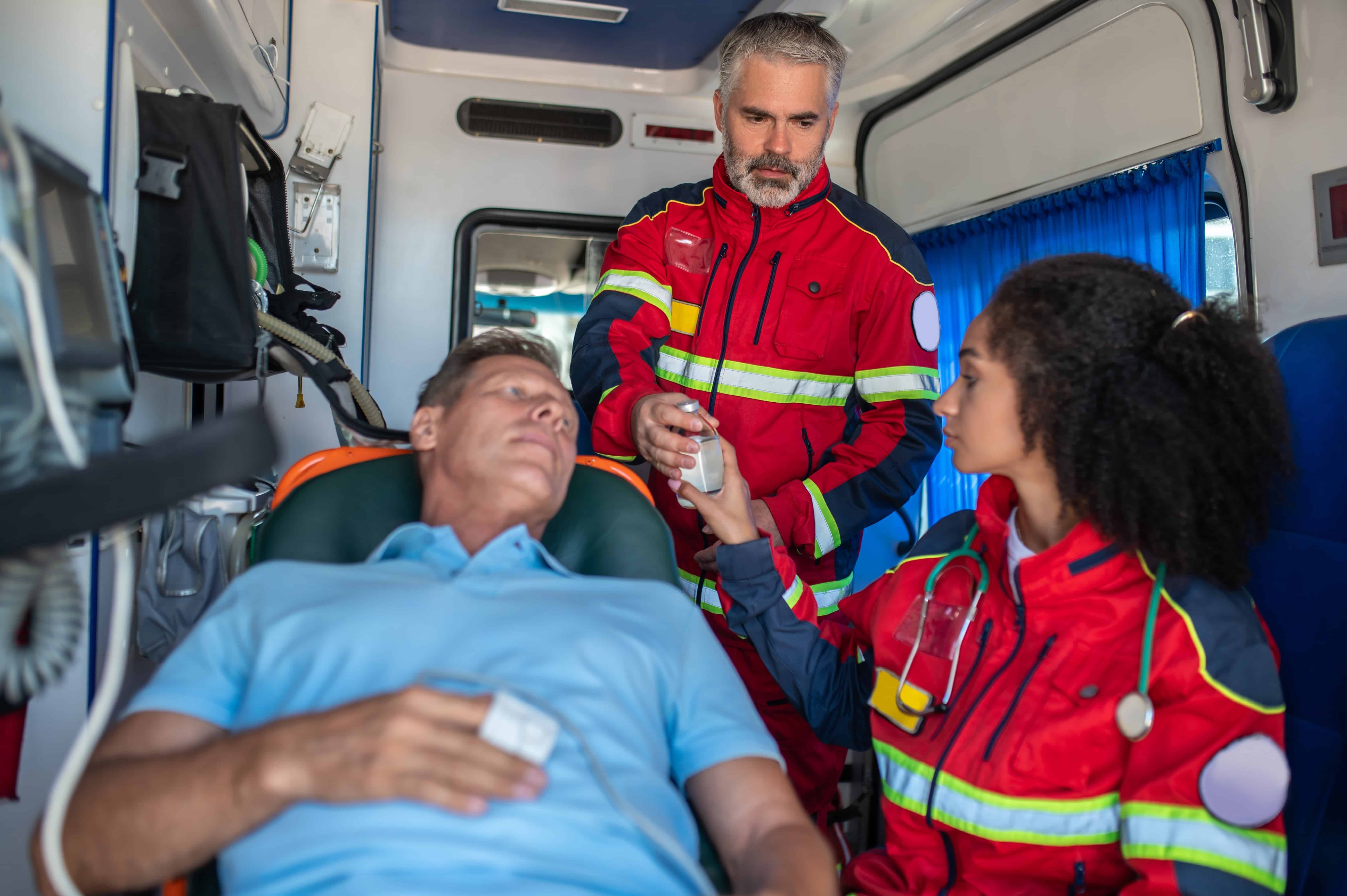 EMS professionals with a middle-aged man in an ambulance