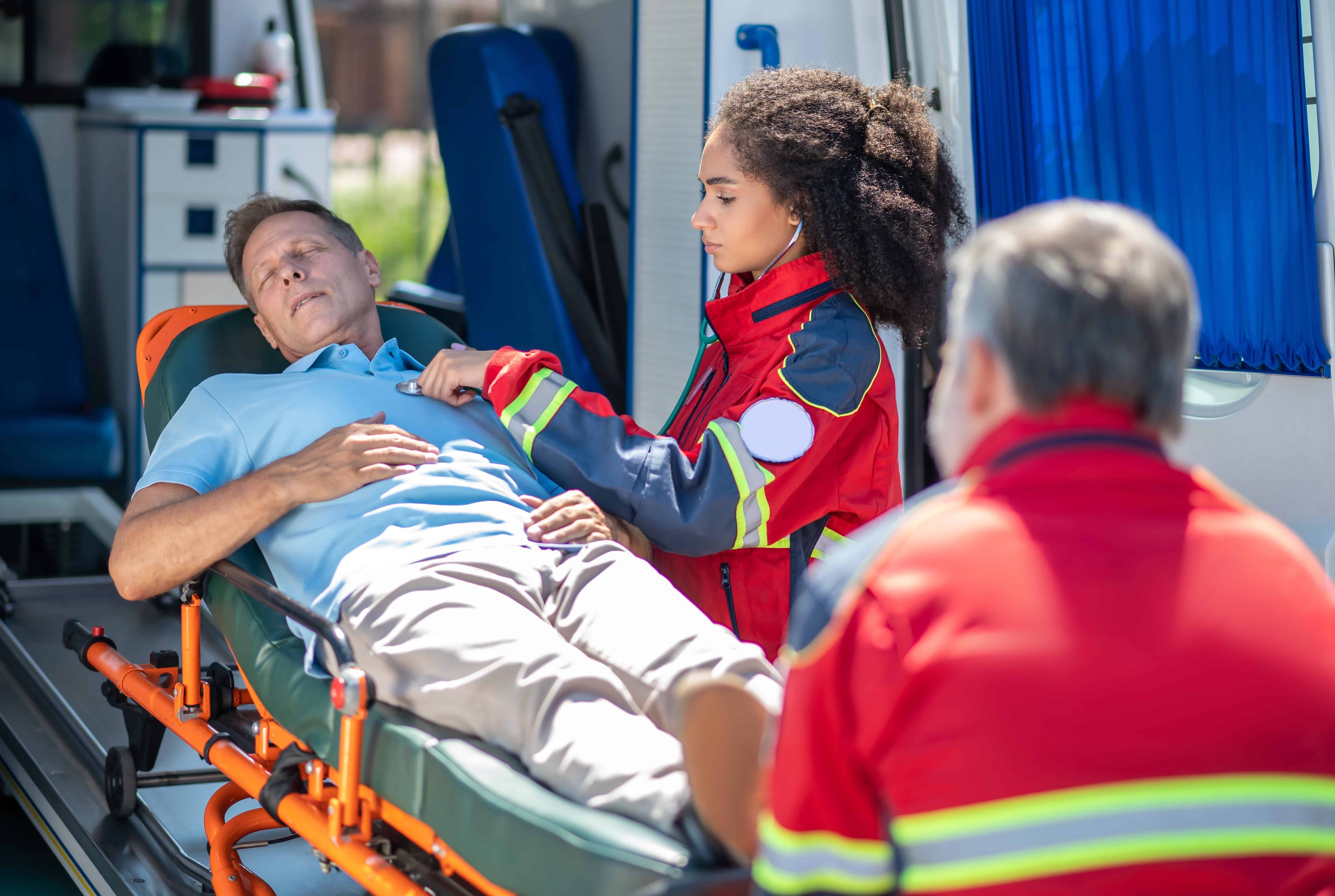 African-American EMS professional checking a man's heart rate