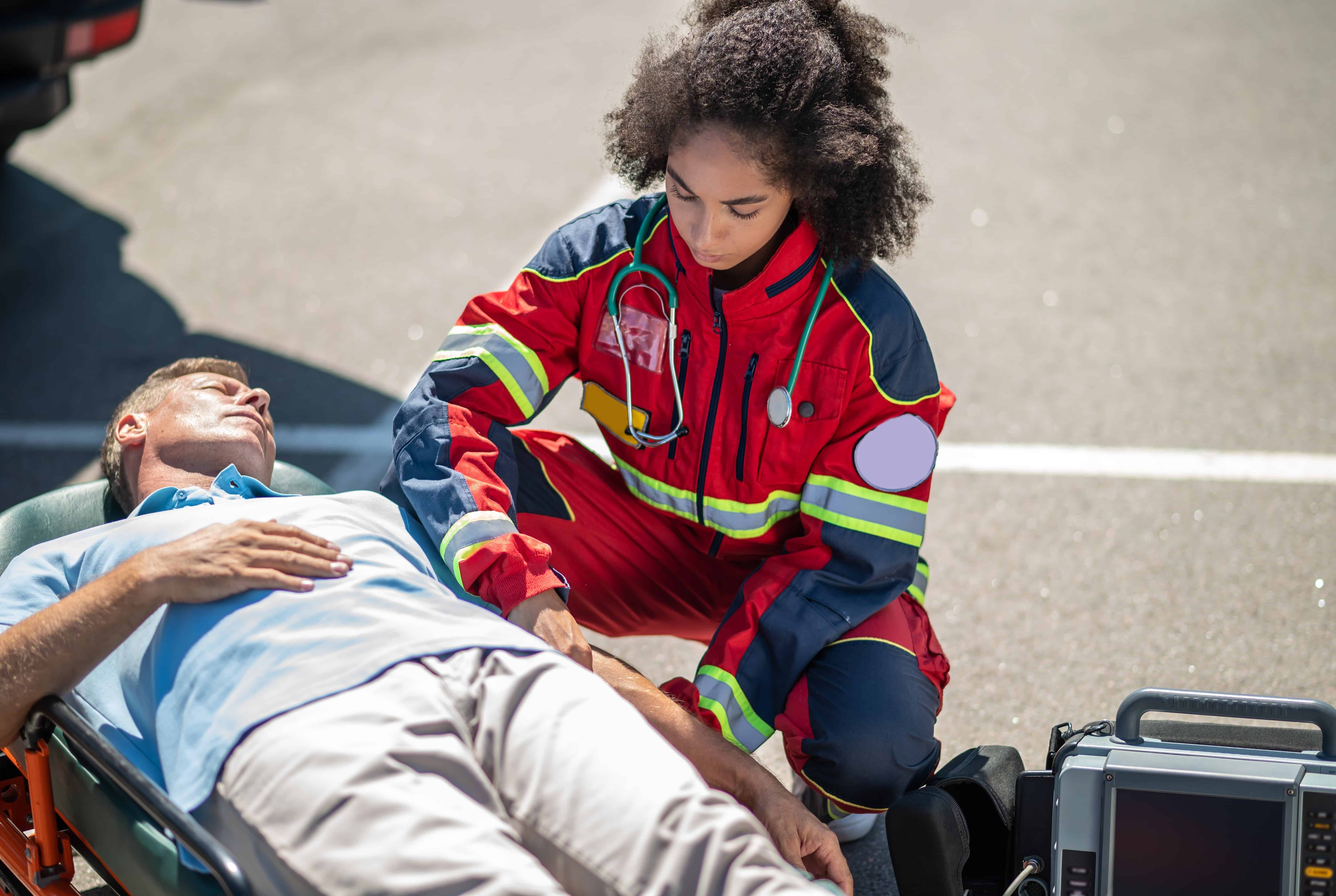 EMS professional assisting a man on a stretcher