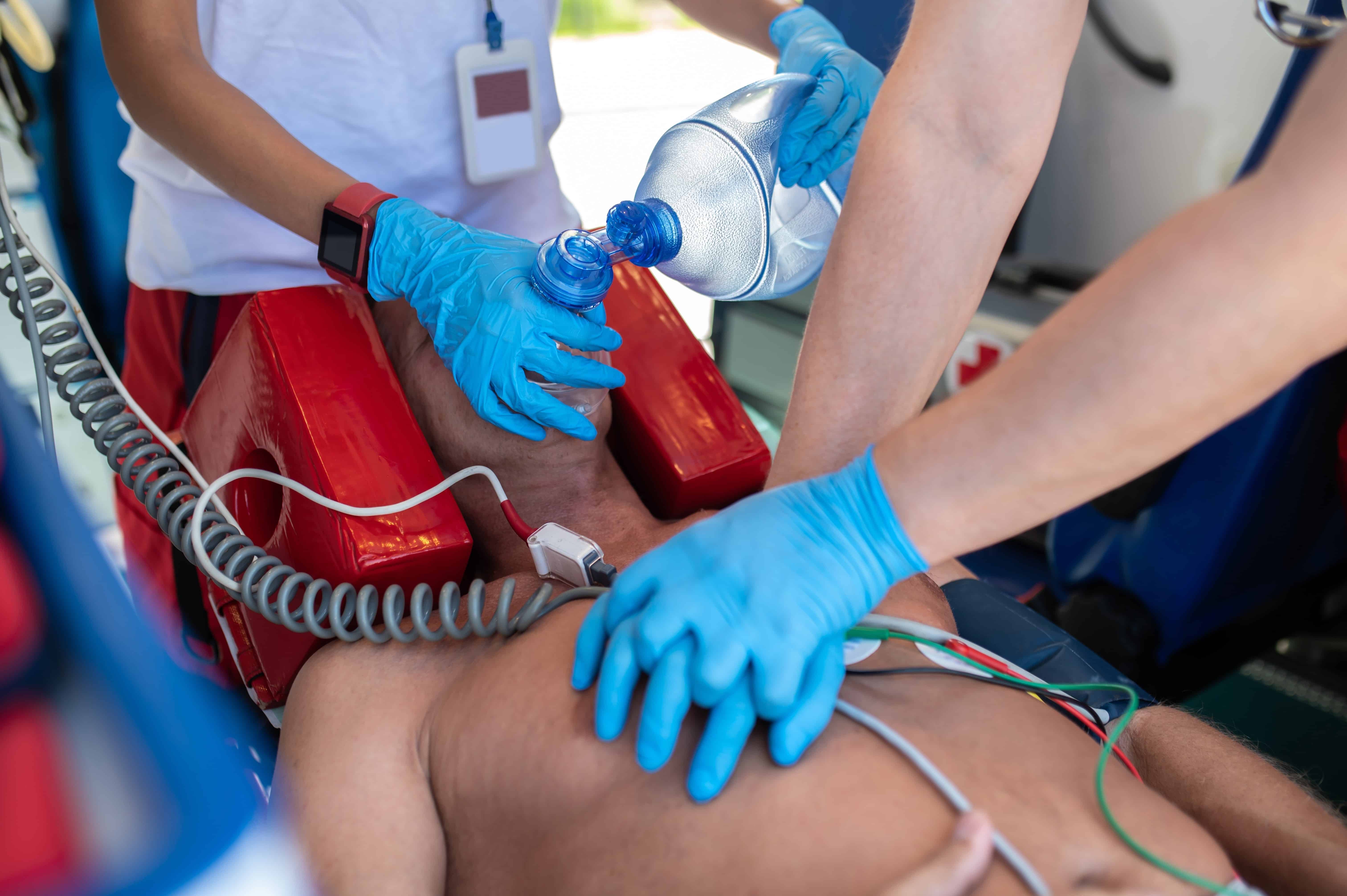 Close up of a man receiving chest compressions from EMS