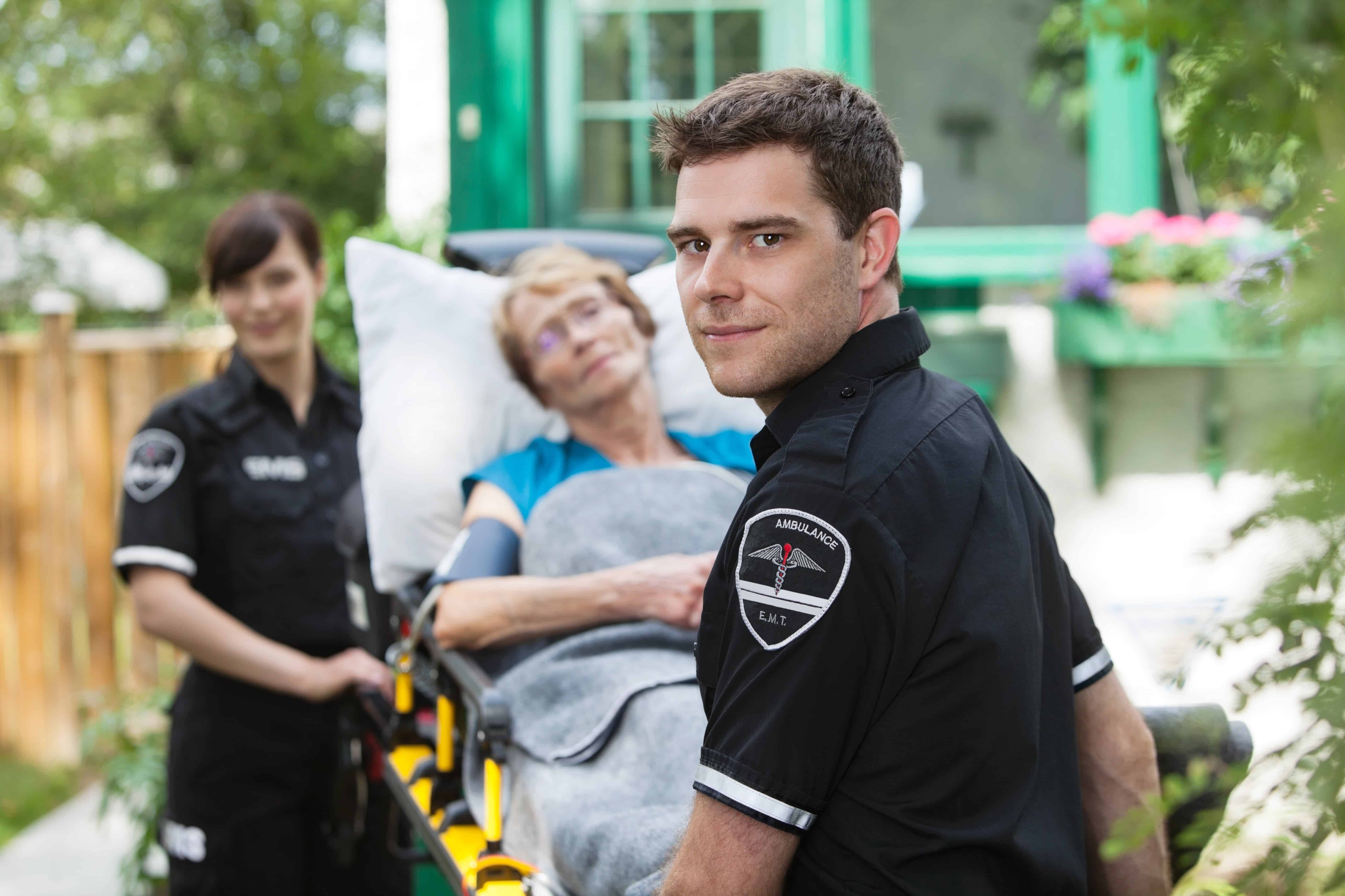 EMS professionals transporting an elderly woman on a stretcher
