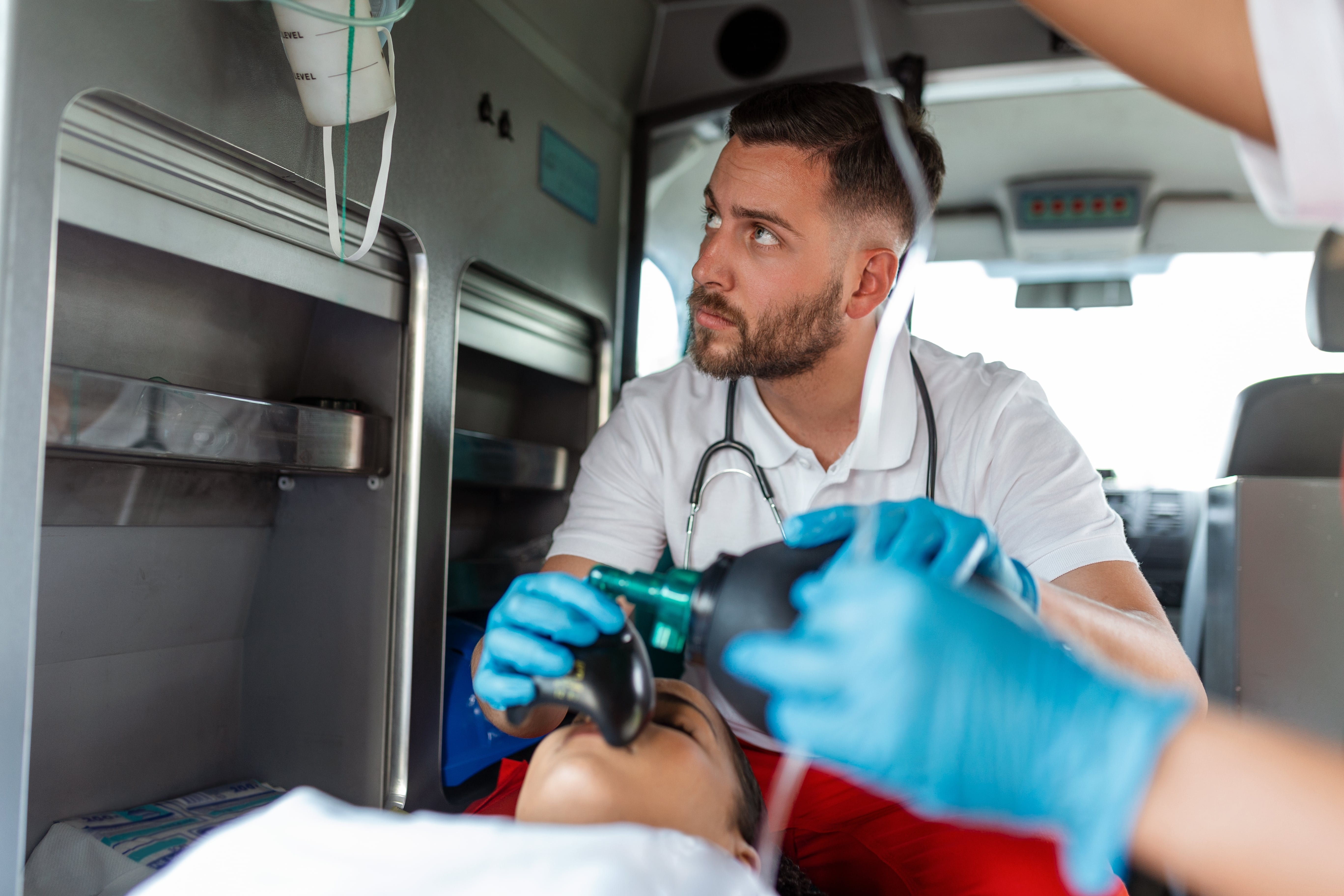 Male EMS professional transporting a woman in an ambulance