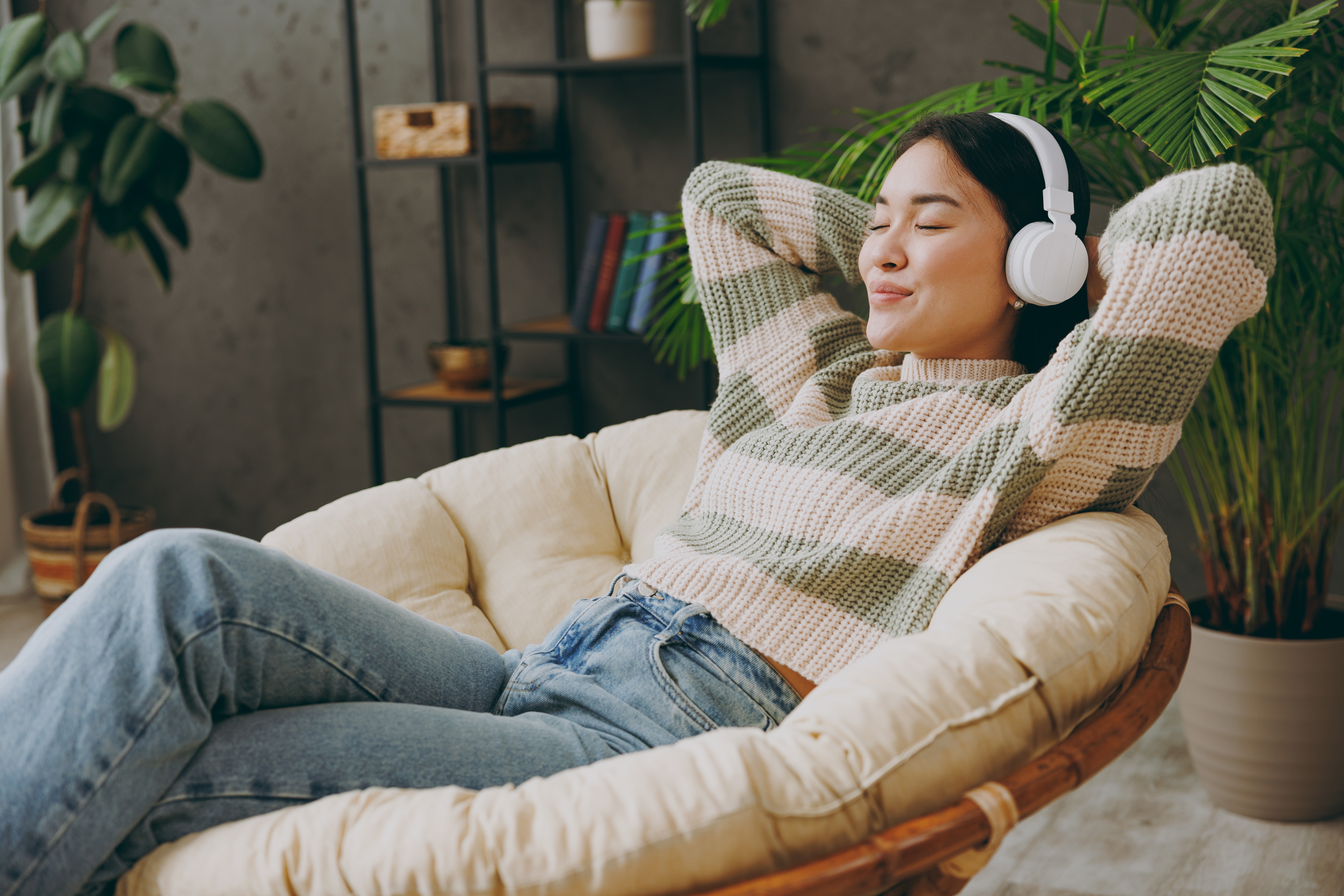 Asian woman wearing headphones and relaxing
