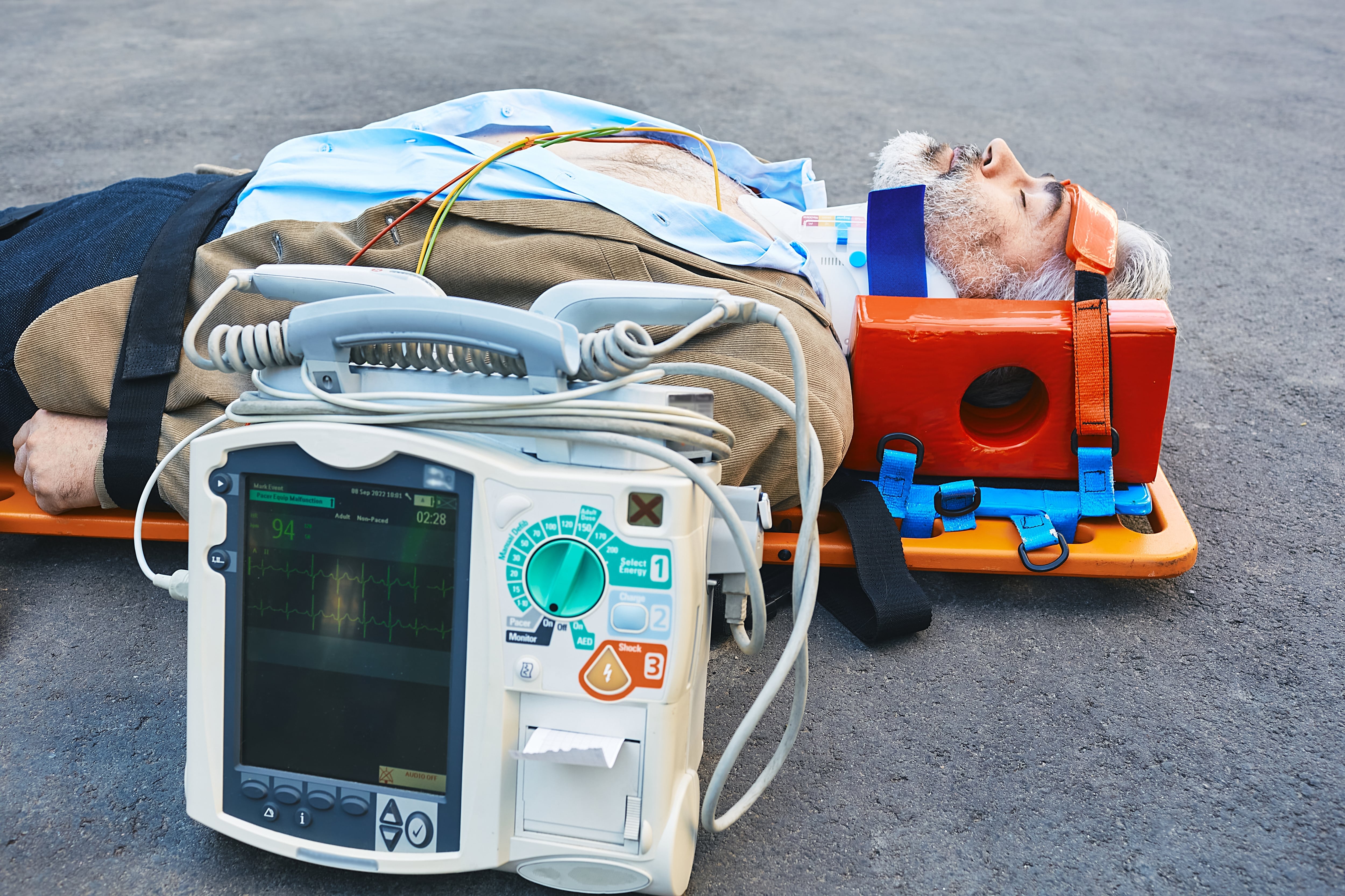 Car crash victim immobilized on the road next to EKG equipment